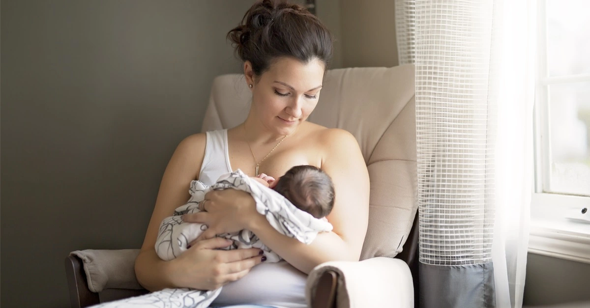 mother breastfeeding her little baby boy in her arms